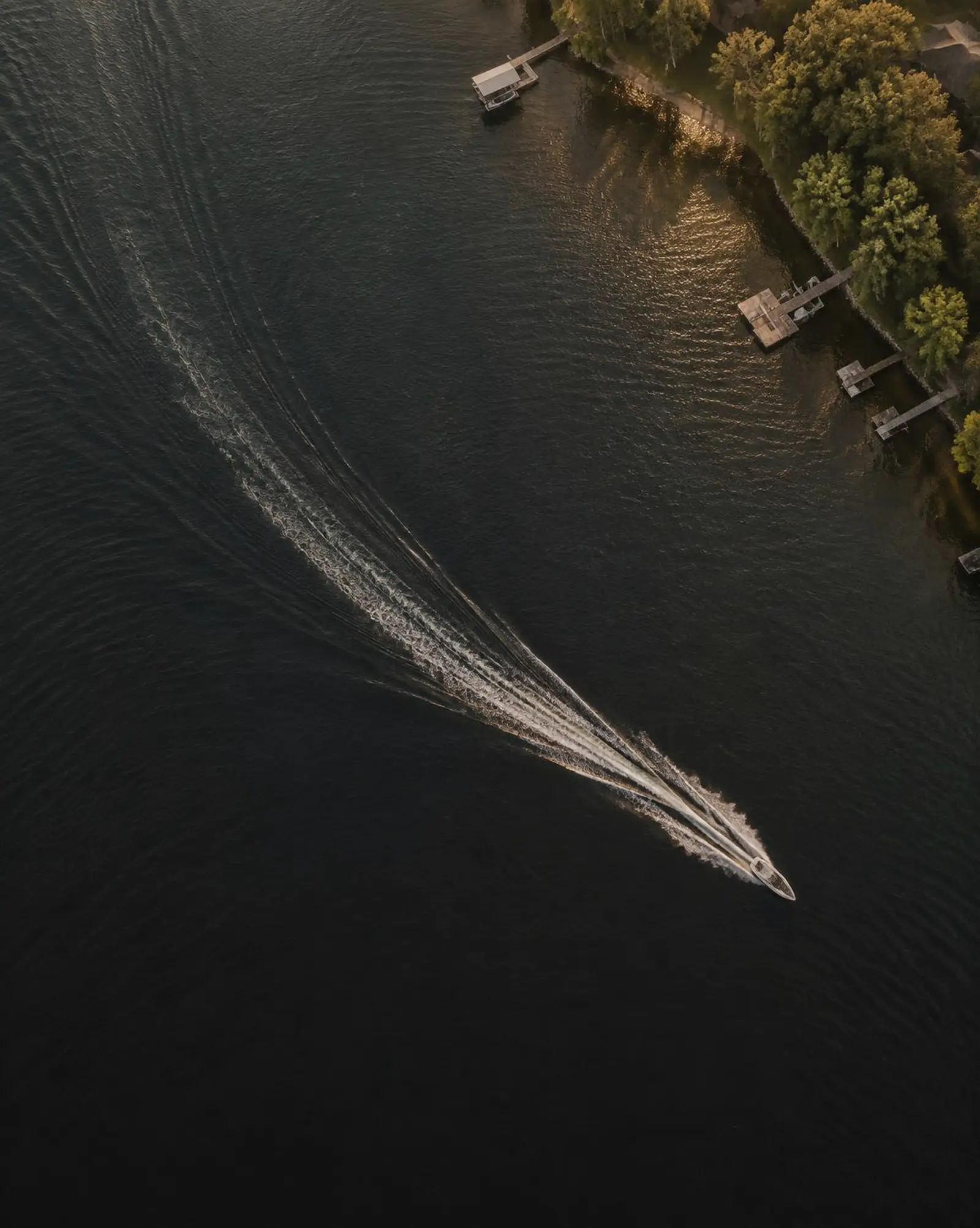 Aerial view of a boat wake on dark water