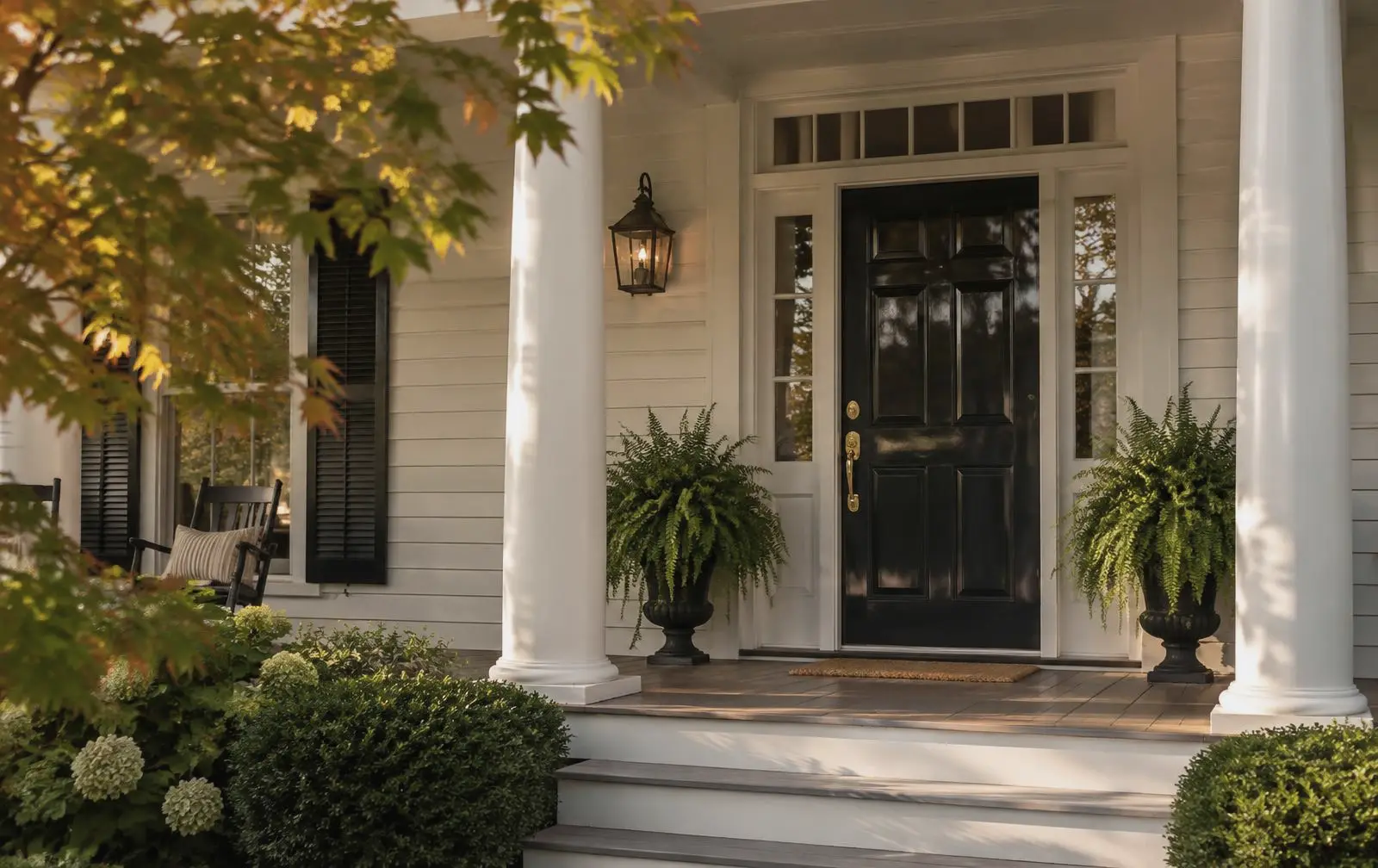 Front porch with a black door and brass hardware